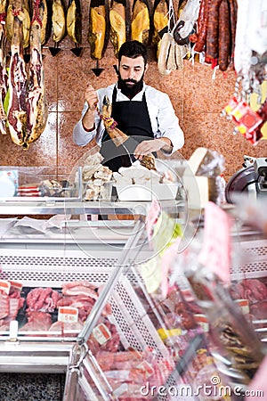 Male shop assistant demonstrating jamon Stock Photo